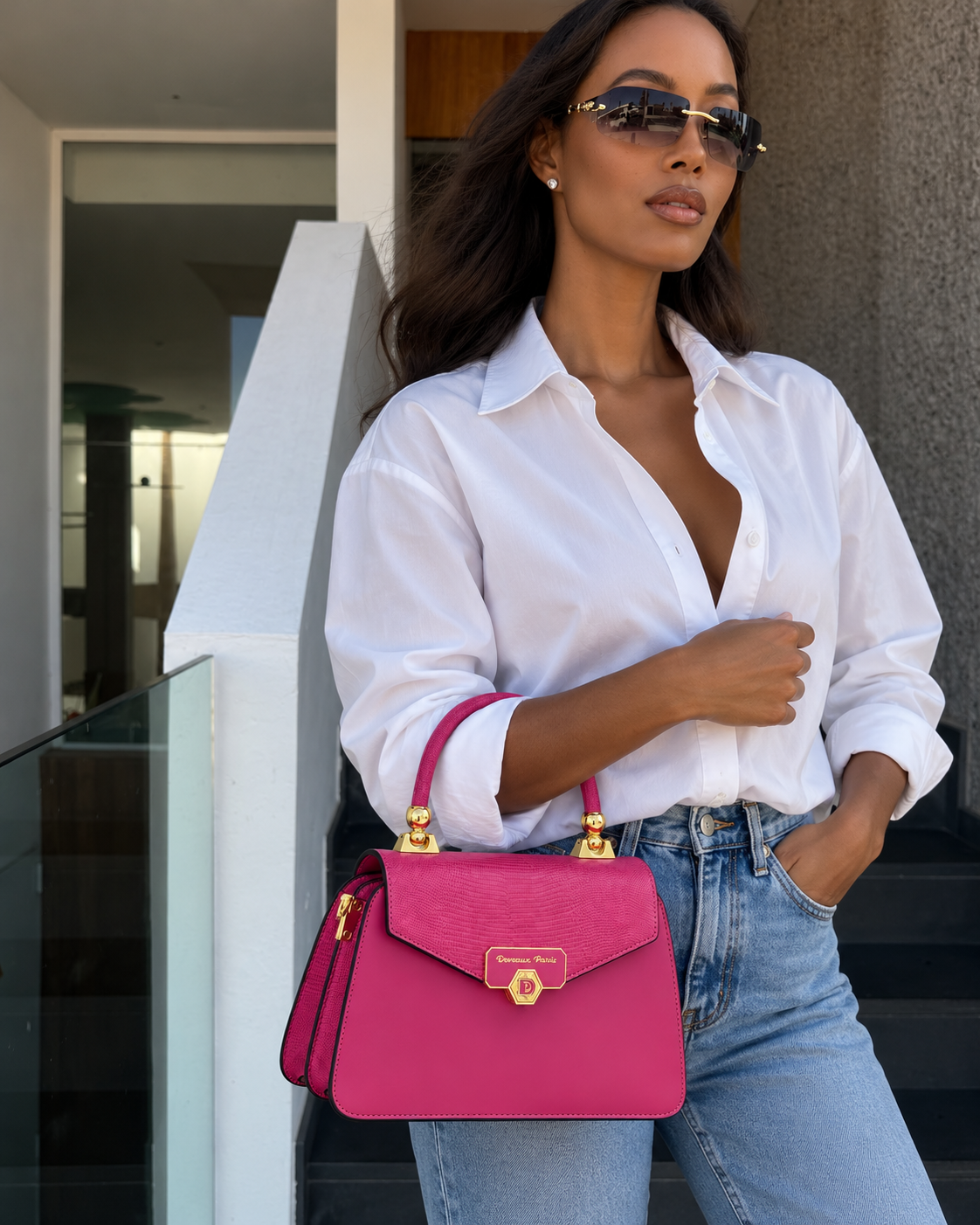 Sac à main Anita fuchsia porté avec une tenue urbaine — Deveaux Paris